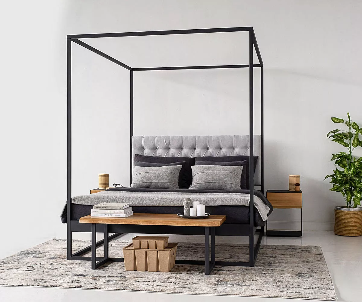TELA Himmelbett mit einer Sitzbank, Nachttisch und einer Pflanze in der Ecke TELA Himmelbett mit einer Sitzbank, Nachttisch und einer Pflanze in der Ecke